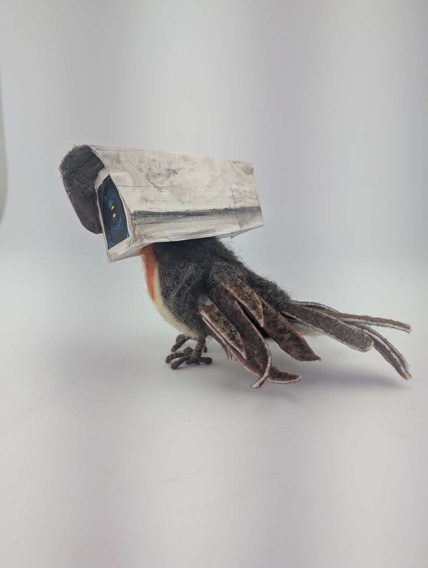 A mixed media sculpture that depicts a robin with the head of an old-timey security camera.